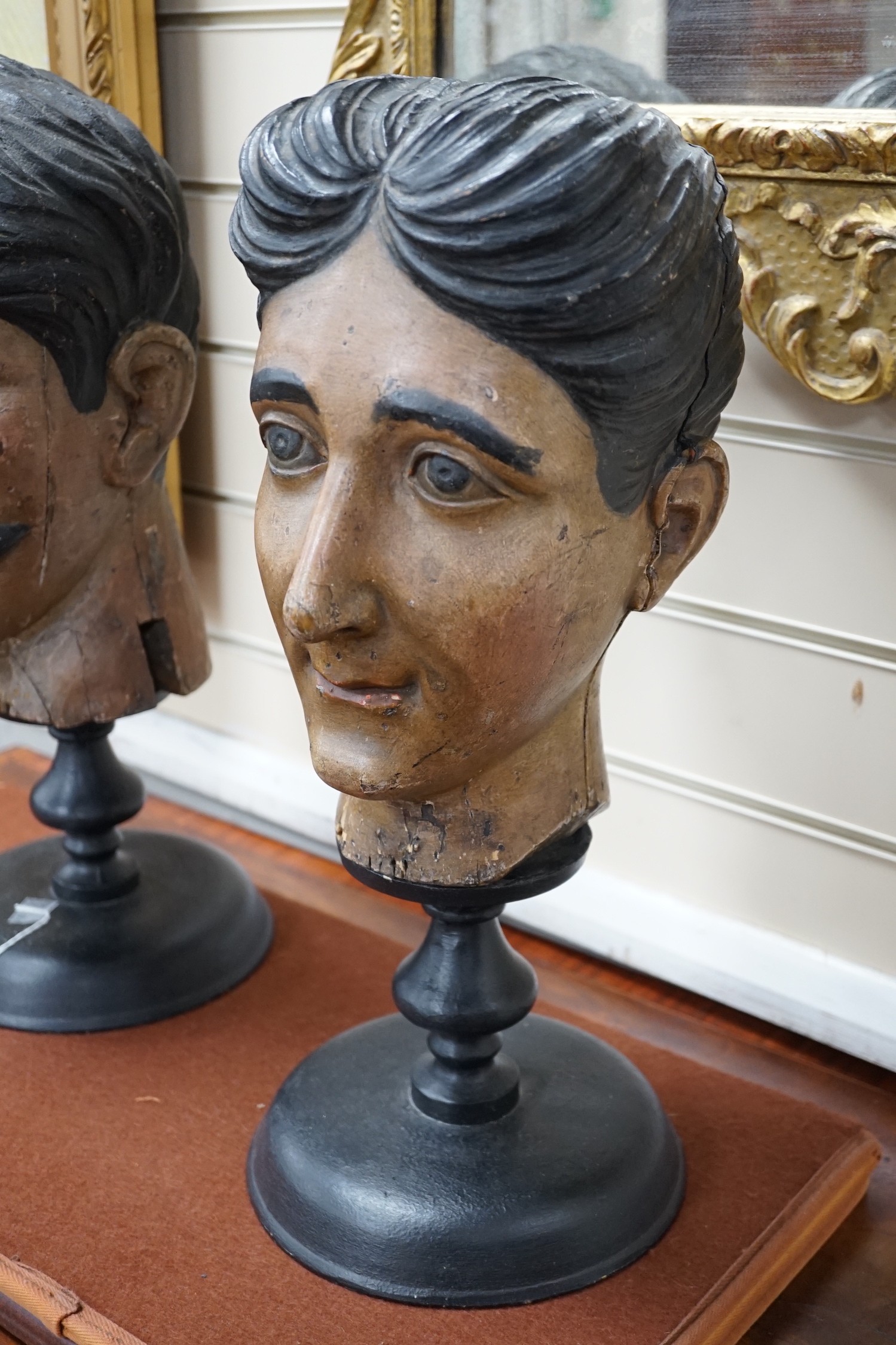Two 20th century Italian carved and painted wooden heads on stands, 47cm